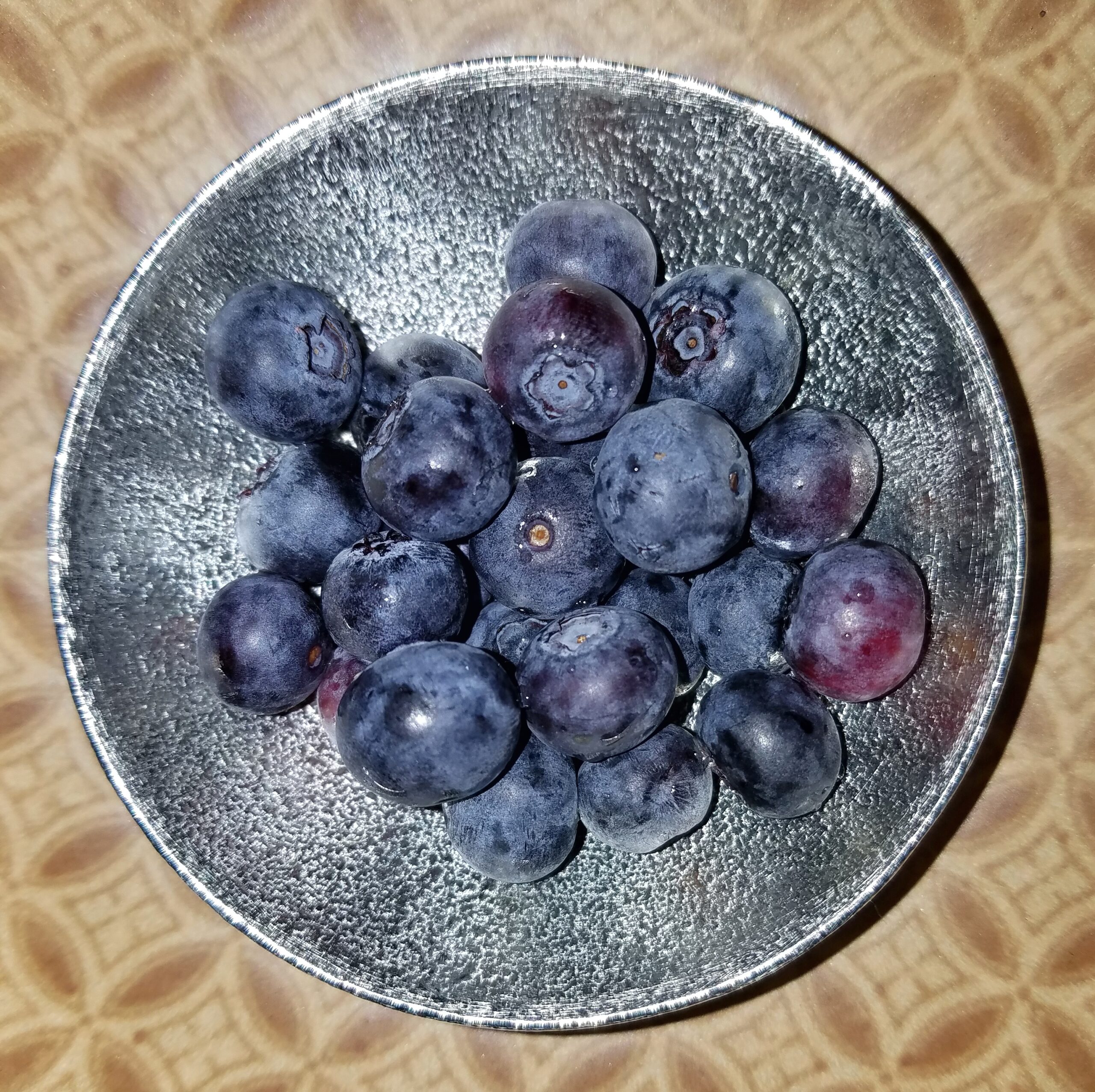 Blueberries in a small silver-colored bowl.