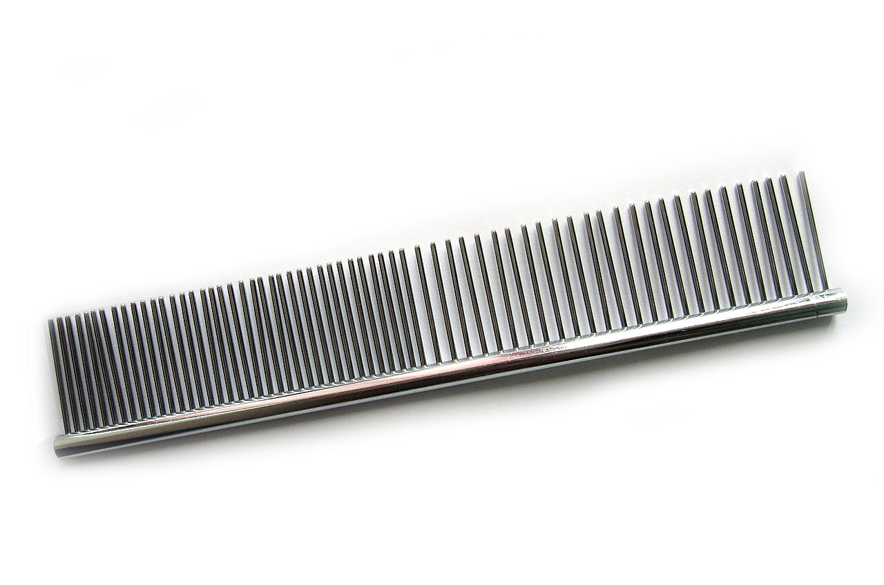 A metal grooming comb with closely and widely spaced teeth on a white background.