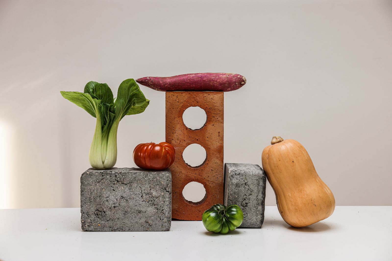 Fresh vegetables including sweet potato and tomatoes on a white background